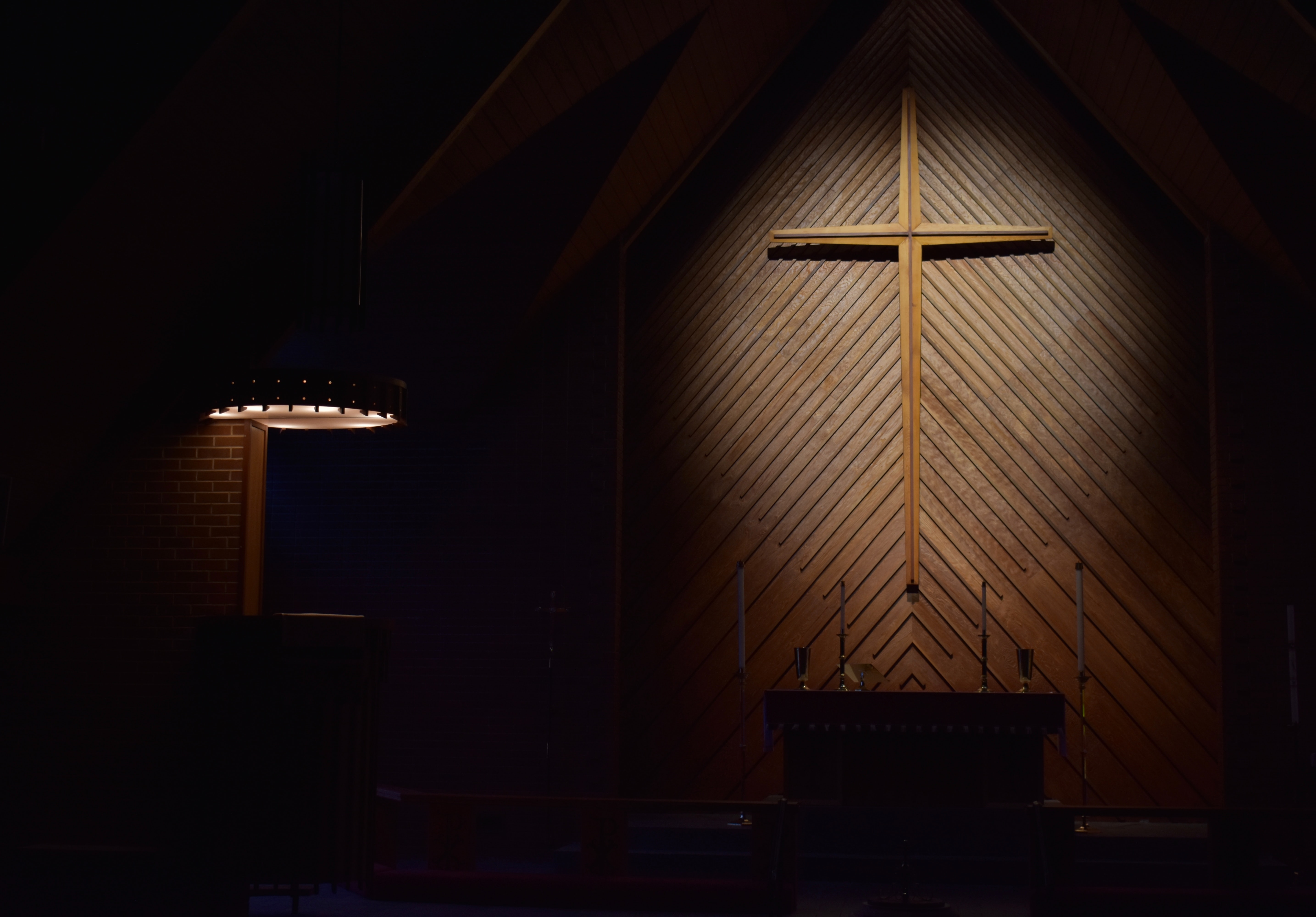 A cross on a wall in a darkly lit church